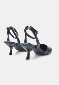 Black leather high-heeled shoes with a pointed toe, ankle strap, and a glossy finish. Features a curved, slender heel.