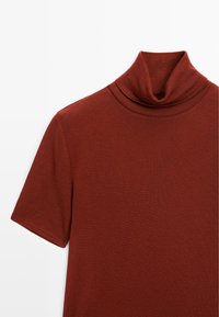 Brown turtleneck shirt with short sleeves, made from a soft, textured fabric, featuring a folded collar and a fitted shape.