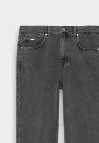 Jeans de mezclilla gris con un diseño estándar de cinco bolsillos, botón de metal y detalles de costura. Textura suave y pierna recta.