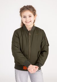 Groene bomberjack met geribde manchetten, een ritssluiting aan de voorkant en een zak op de linker mouw. Heeft een oranje label aan de zoom.