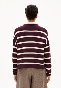 Pullover in Dunkelburgunder mit horizontalen weißen Streifen. Verfügt über einen runden Ausschnitt und eine lockere Passform. Weiche Stricktextur.