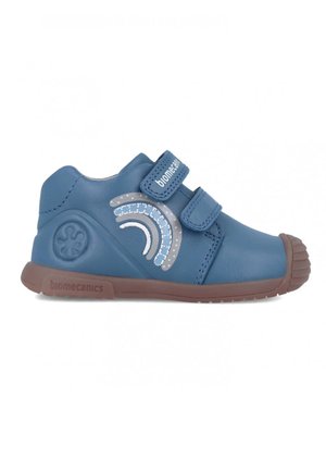 Scarpa in pelle blu con due cinturini in velcro, suola in gomma e un motivo decorativo di arcobaleno argentato sul lato. Design della punta arrotondata.