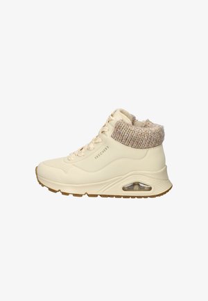 Beige high-top sneaker with a textured knit collar, lace-up front, and a visible air-cushioned midsole. Rubber outsole for traction.