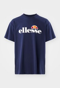 Tumši zilas krāsas kokvilnas T-krekls ar īsām piedurknēm, apaļu kakla izgriezumu un baltu "ellesse" logotipu ar sarkanu un oranžu pusapļa akcentu.
