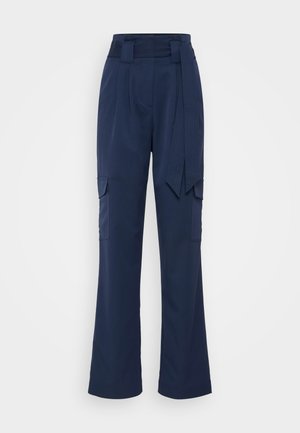 Ναυτικό μπλε παντελόνια κομμένα σε χαλάρωμα, φτιαγμένα από ελαφρύ ύφασμα, με ζώνη στη μέση και δύο τσέπες cargo στα πλάγια.