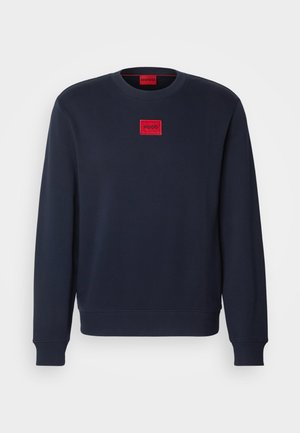 Navy blue sweatshirt in soft fabric, featuring a rounded neck, ribbed cuffs, and a red square logo patch on the chest.