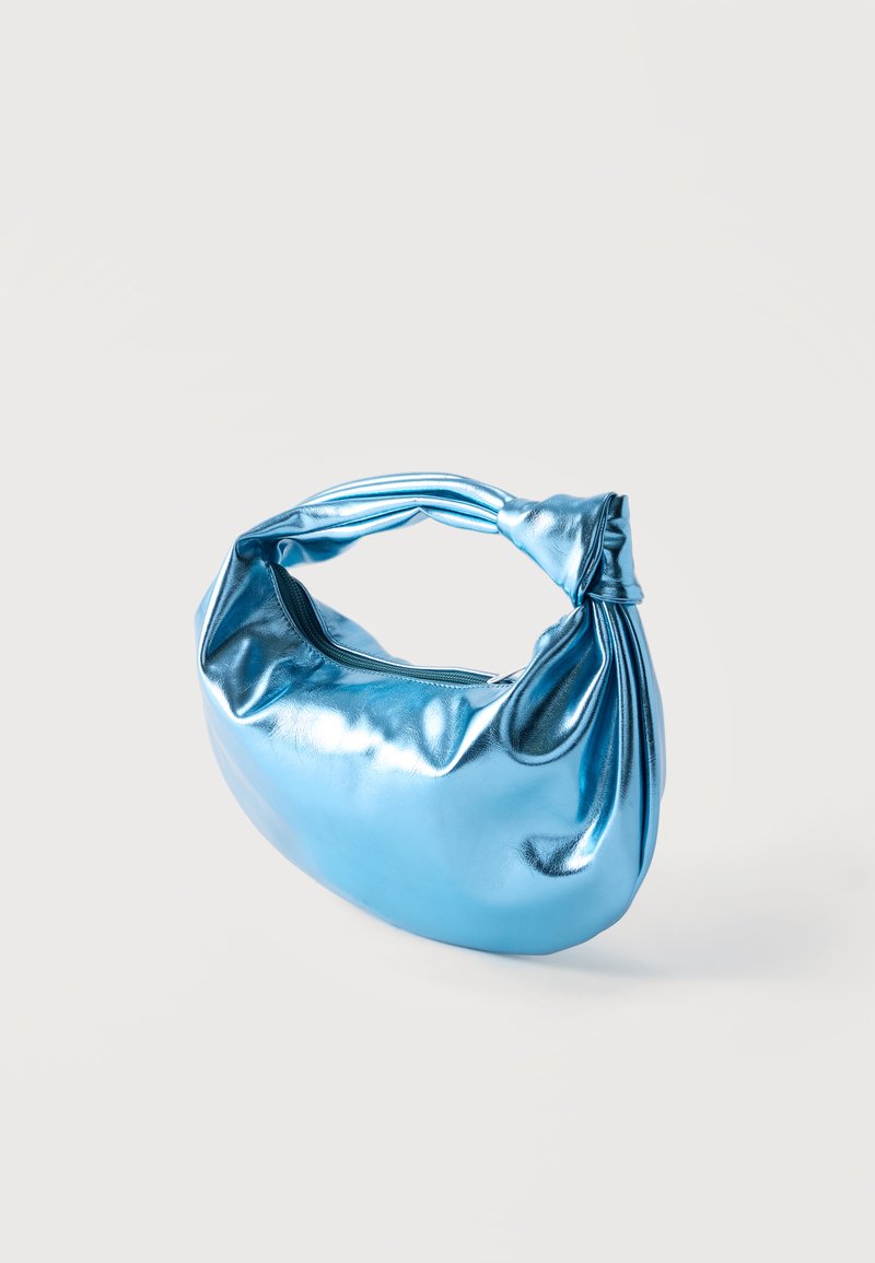 Bolso azul metálico brillante con una asa anudada y cierre de cremallera, exhibido sobre un fondo claro y liso.