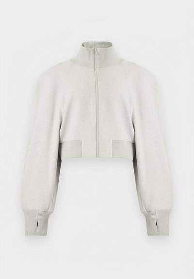 Ανοιχτό γκρι κοντό πουλόβερ με φερμουάρ, ψηλό ριμπ πλεκτό γιακά, μακριά φουσκωτά μανίκια και ριμπ μανσέτες με άνοιγμα για τον αντίχειρα.