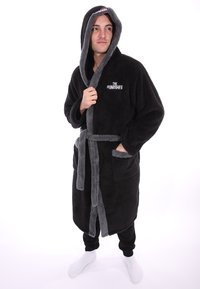 Zwarte pluche badjas met grijze accenten en capuchon, met het logo van "THE PUNISHER". Het heeft een strikceintuur en twee voorzakken.