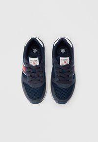 Σκουρό μπλε αθλητικά παπούτσια από δίχτυ και σουέτ με λ�ευκές και κόκκινες λεπτομέρειες, στρογγυλή μύτη, κλείσιμο με κορδόνια και λογότυπο στη γλώσσα.