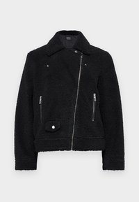 Zwarte neplederen shearling jack met een kraag, rits aan de voorkant, twee zijzakken en een drukknoopdetail aan de onderkant links.