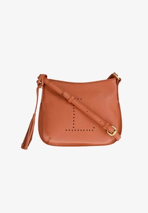 Sac bandoulière en cuir marron avec sangle réglable, motif perforé en forme de L sur le devant, et détail pompon sur le côté sur fond blanc.