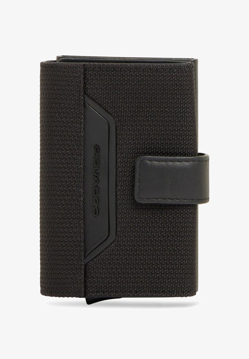 Cartera de tela texturizada negra con una correa de cuero y el nombre de la marca grabado en relieve en un pequeño parche de cuero, plegada y cerrada.