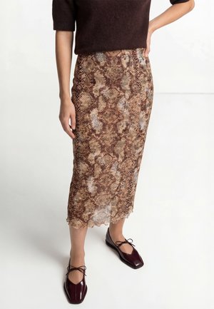 Brauner Midi-Rock mit Schlangenhautmuster aus leichtem Stoff und gewelltem Saum, kombiniert mit flachen bordeauxroten Schuhen mit Schnürdetail.