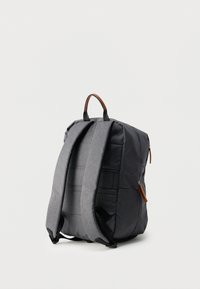 Γκρι υφασμάτινο σακίδιο με δομημένο σχέδιο, δερμάτινες λεπτομέρειες και επενδεδυμένους ιμάντες. Διαθέτει επάνω λαβή και πλευρικό φερμουάρ.