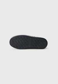 Semelle de chaussure en caoutchouc noir avec une texture grip en motifs de diamant. Bords courbés et légère arche pour le confort. Design épuré et minimal.