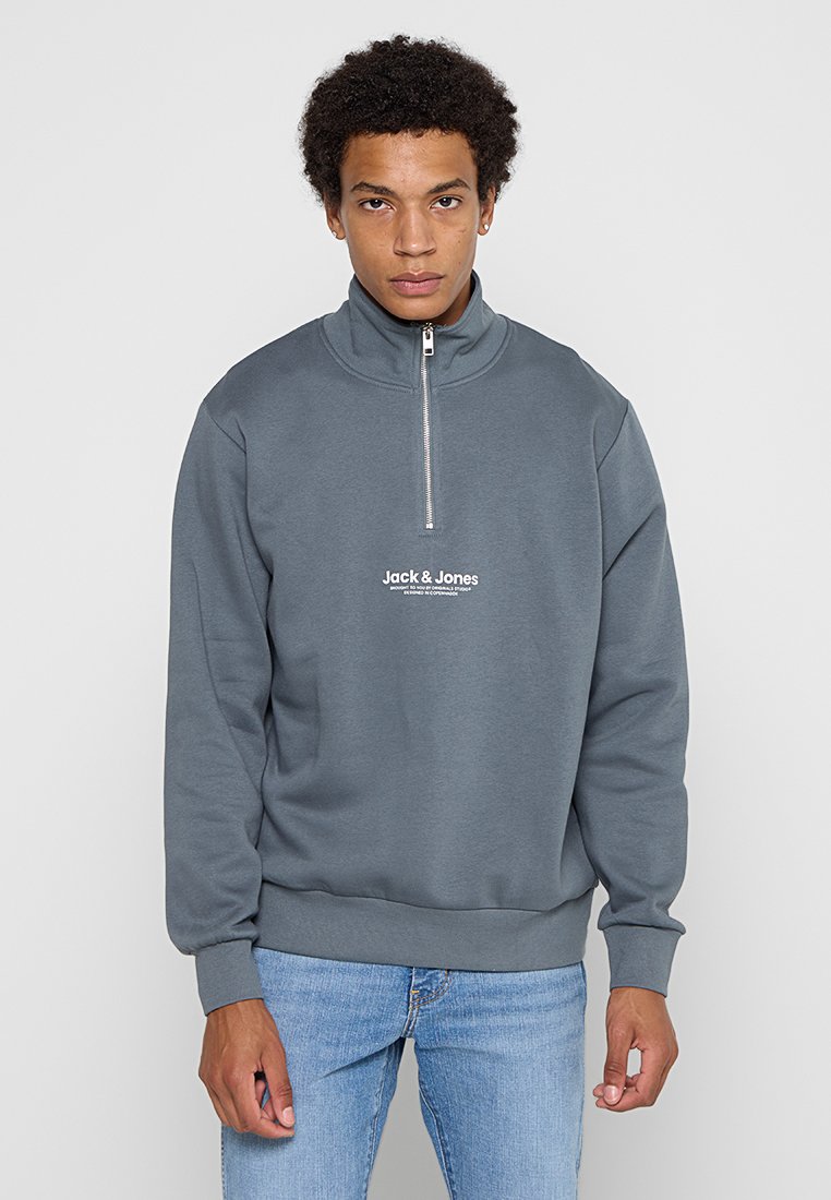 Grauer Sweatshirt mit Viertelreißverschluss, aus weichem Stoff, mit geripptem Saum und Bündchen. Auf der Vorderseite befindet sich das weiße "Jack & Jones"-Logo.