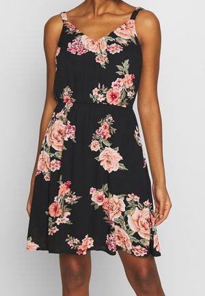 Robe d'été noire à motifs floraux avec des roses roses et vertes, décolleté en v, bretelles réglables et jupe fluide avec taille élastique.