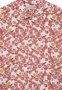 Camicia bianca con bottoni, caratterizzata da un complesso motivo floreale rosso e giallo con dettagli paisley, realizzata in tessuto leggero.
