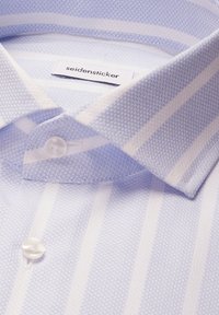 Hellblau-weiß gestreiftes Hemd mit strukturierter Stoffoberfläche, geknöpftem Kragen und sichtbarem "seidensticker" Markenlabel im Innenkragen.