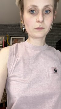 Maglietta senza maniche rosa chiaro realizzata in tessuto morbido, con scollo rotondo e un piccolo patch con logo nero sul lato sinistro.