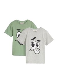 Due magliette a maniche corte: una verde con una grafica di un volto sorridente, l'altra grigia con una grafica di un volto buffo, entrambe realizzate in morbido tessuto di cotone.