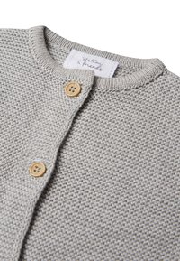 Grau gestrickte Strickjacke mit einem strukturierten Muster, geripptem Kragen und zwei Holzknöpfen. Das Etikett lautet "Stellou & Friends."