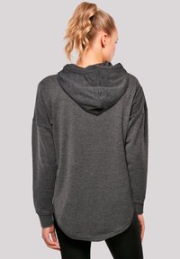 Gray hoodie with a textured, soft fabric; long sleeves, back cut longer than the front; features a spacious hood and ribbed cuffs.