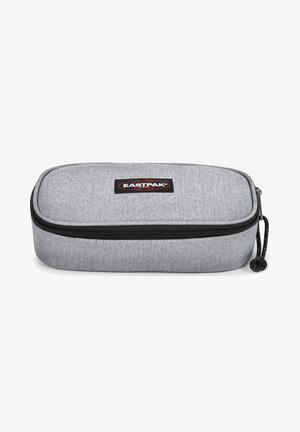Estuche de lápices gris de tela con cierre de cremallera y bordes redondeados, cremallera negra y cordón negro. Presenta un pequeño logotipo de Eastpak en la parte frontal.