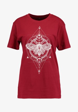 Rotes Baumwoll-T-Shirt mit einem großen weißen Graf design eines Nachtfalters, umgeben von geometrischen Formen, Sternen und Halbmonde.