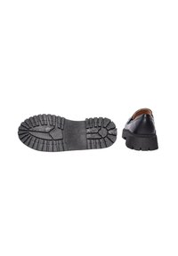 Scarpa in pelle nera con suola in gomma spessa e strutturata, dotata di profonde scanalature per la trazione. La vista laterale mostra una punta arrotondata e un design con tacco corto.