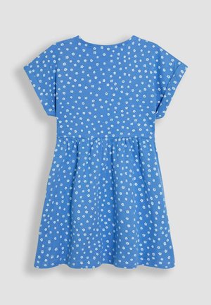 Modrá bavlnená šaty s krátkymi rukávmi, ozdobené bielou kvetinovou potlačou, s riasiacim pásom a rozšírenou sukňou. Zobrazený zadný pohľad.