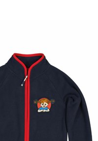 Marineblå fleecejakke med rød lynlås og trim. Har et farverigt broderet mærke af et barn med fletninger på brystet.