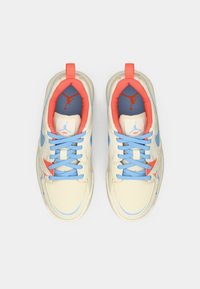 Par tenisica boje kreme s plavim vezicama, koraljnim unutarnjim oblogama i plavim i koraljnim detaljima loga, prikazane iznad na bijeloj pozadini.