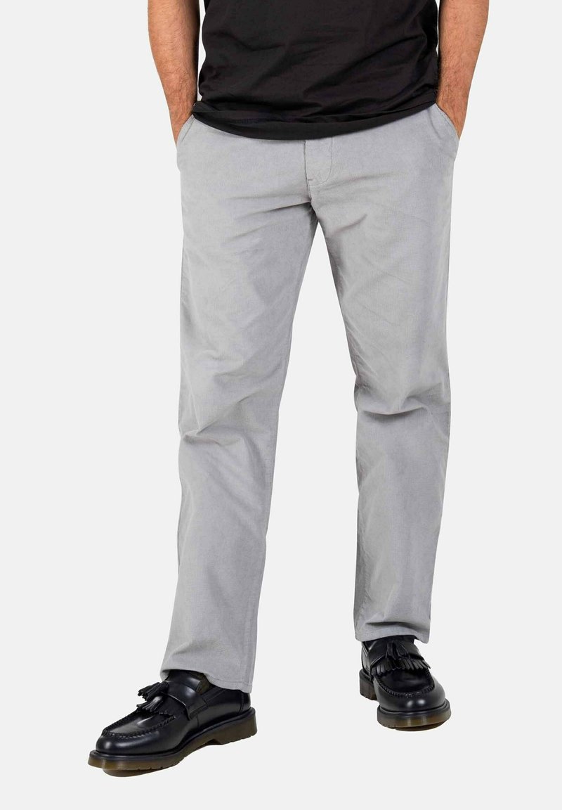 Light grey trousers made from a smooth fabric, featuring front pockets and a straight-leg cut. Paired with black loafers and a black shirt.