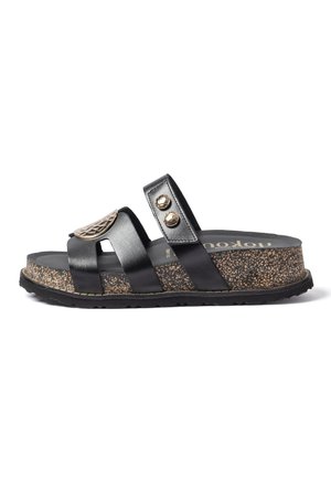 Sandalia tipo slide negra con suela plataforma con diseño de corcho, dos tiras incluyendo una con botones metálicos y un emblema decorativo dorado.