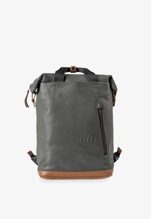 Gray leather backpack with a roll-top design, tan bottom accent, side zipper pocket, and black webbing handles. Textured surface.