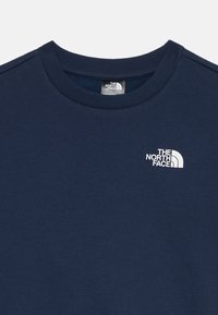 Mörkblå bomullssweatshirt med ribbad rundhals. Har en vit logotyp på vänster bröst. Slät textur med enfärgad design.