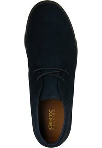 Zapato de ante azul oscuro con puntera redonda, diseño con cordones, suela de goma y marca Geox visible en la plantilla.