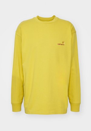 Camisa de manga longa amarela, feita de algodão, com decote redondo e um pequeno logótipo da Carhartt em vermelho na parte superior esquerda do peito.