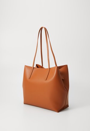 Sac fourre-tout synthétique marron avec deux longues poignées, présentant une texture lisse et une forme structurée, une ouverture sur le dessus et un design minimaliste.