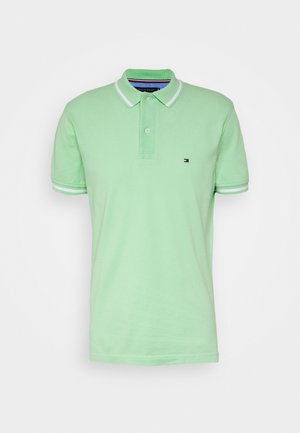 Light green polo shirt made of soft cotton with a two-button placket, white collar and sleeve accents, and a small logo on the chest.