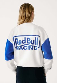 Felpa bianca e blu con un grande logo "Red Bull Racing" sul retro, maniche a contrasto e vestibilità rilassata.