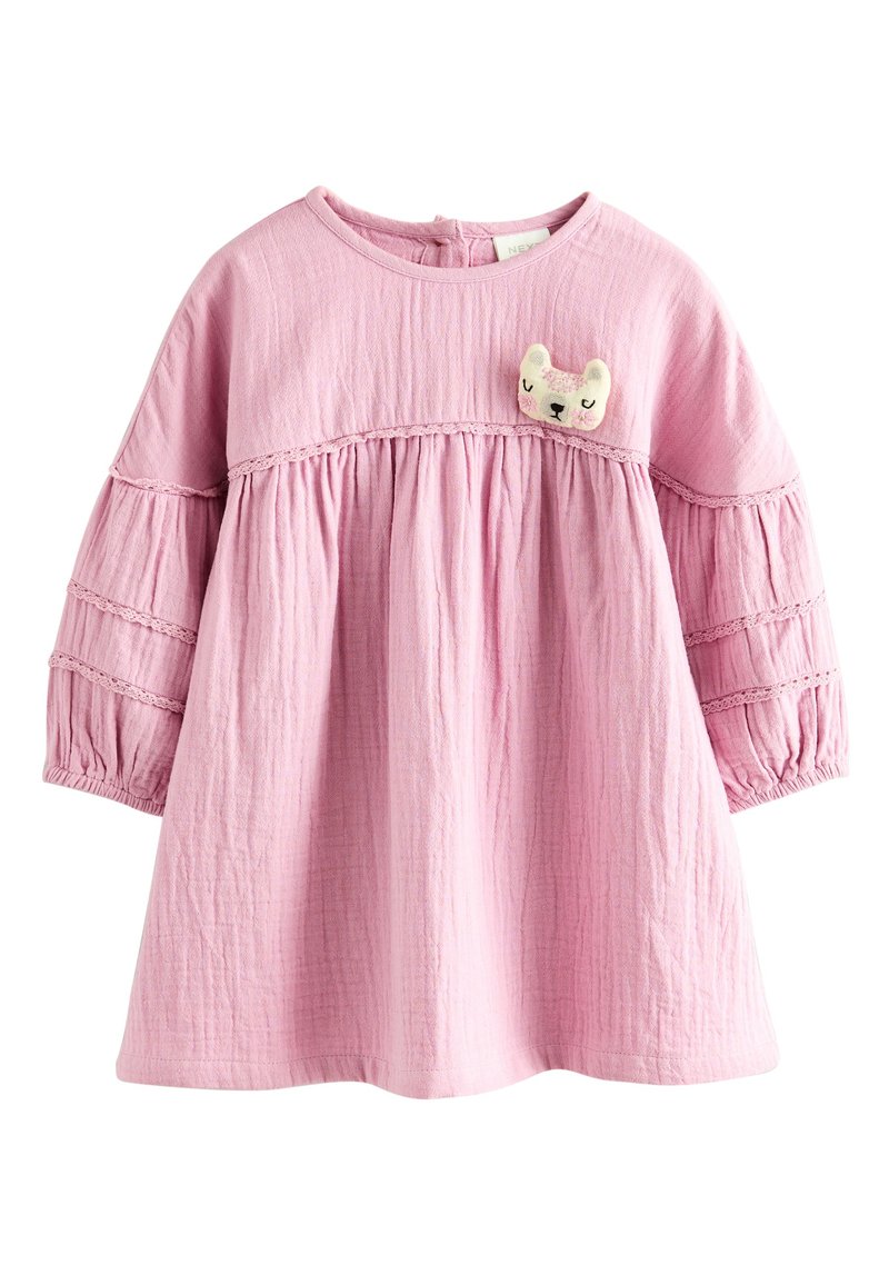 Robe en coton rose avec manches longues bouffantes et design à volants. Caractérisée par un tissu texturé et une mignonne appliqué d'animal sur le devant.
