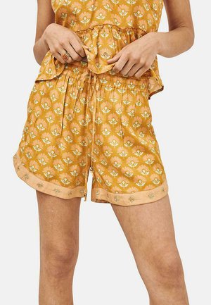 Pantalones cortos de estampado floral amarillo con cintura elástica, sutiles acentos melocotón y bordados decorativos a lo largo del dobladillo. Tela ligera.