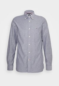 Camicia a maniche lunghe di colore blu chiaro, con colletto a bottoni e piccolo logo Tommy Hilfiger sul petto.