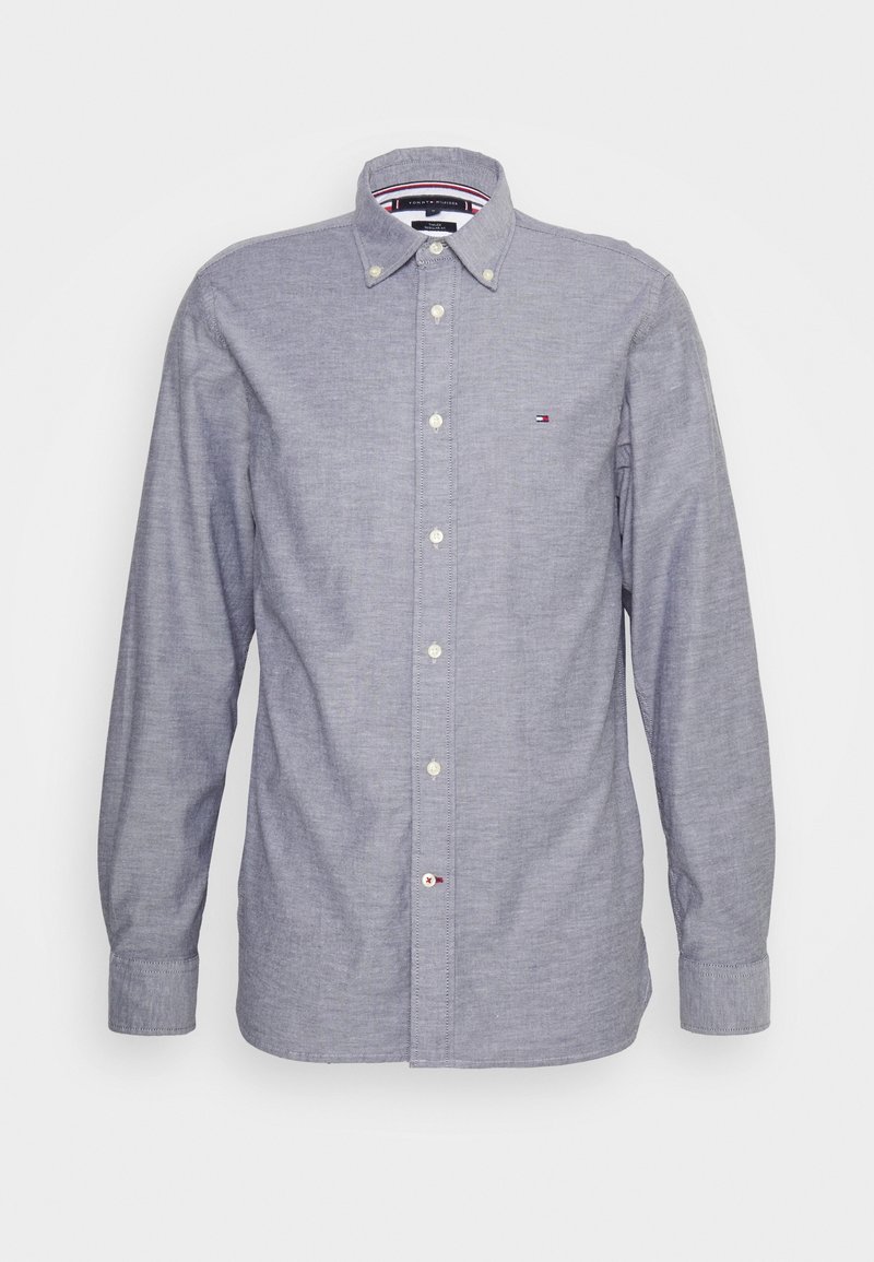 Camicia a maniche lunghe di colore blu chiaro, con colletto a bottoni e piccolo logo Tommy Hilfiger sul petto.