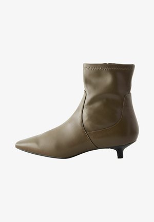 Oliivroheline nahkne põlvekott, terava varbaga, peene stiletto kontsaga ning siledapinnaga, millel on minimaalne õmbluste detail.