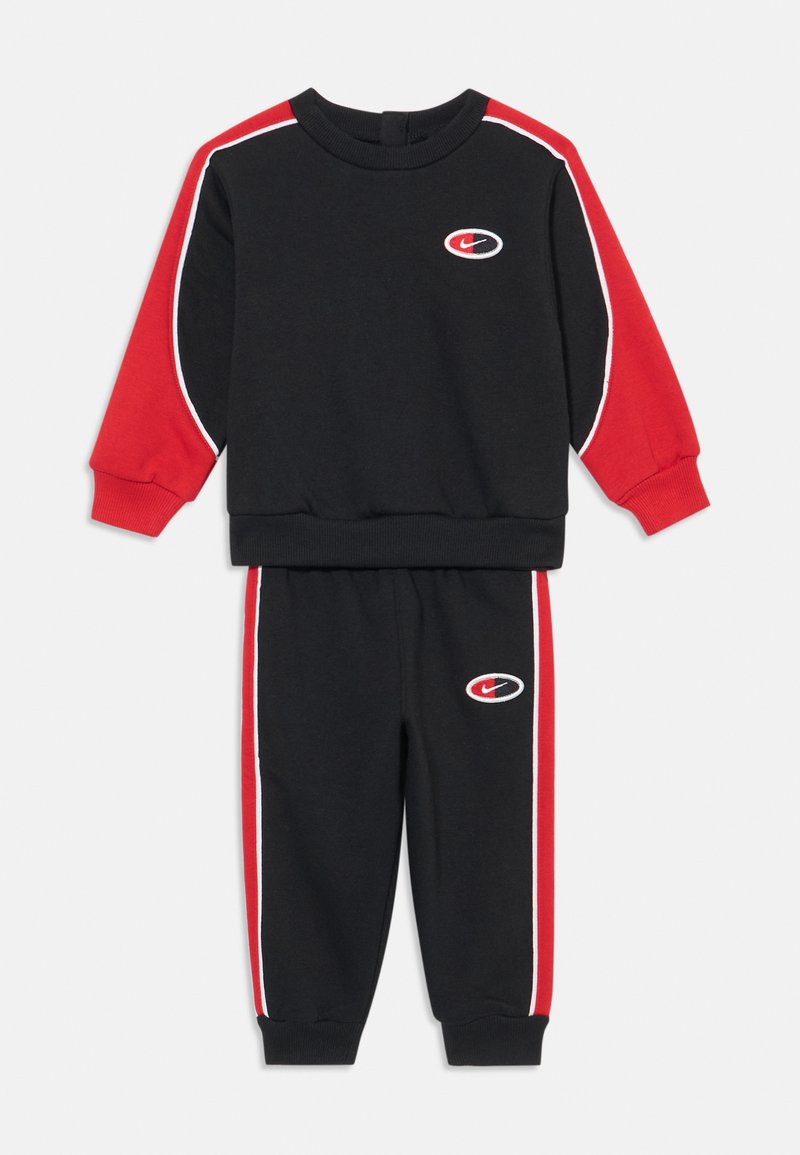 Conjunto de treino preto com detalhes em vermelho, composto por uma t-shirt de manga longa com gola redonda e calças estreitas. Pormenores em branco e logotipo em ambas as peças.