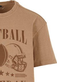 Brun bomuld t-shirt med korte ærmer, prydet med et grafisk motiv af en fodboldhjelm og ordet "FODBOLD" i store brune bogstaver.
